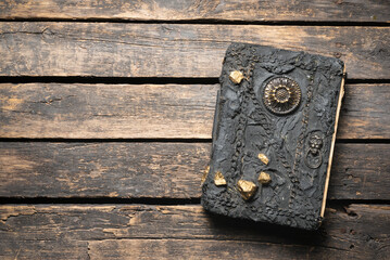 Magic book on the old wooden table flat lay background with copy space.