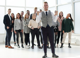 Fototapeta premium smiling young man standing in front of his colleagues