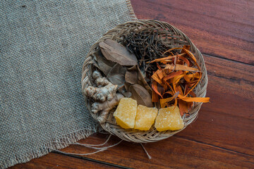 Traditional herbal ingredients of empon empon or root plants that are good for health and treatment in a bamboo basket, including turmeric, ginger, temulawak, galangal, wedang uwuh, and others