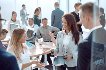 business woman talking to her colleagues standing in the office