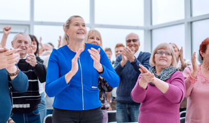 a group of elderly people are sitting in a circle clapping their