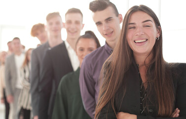 Obraz premium smiling young woman standing in front of a group of diverse young people