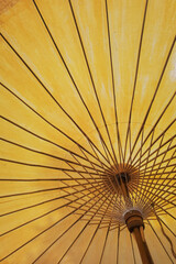 close up of under a yellow umbrella of its metal frames