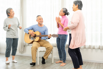 Obraz premium Group of senior people enjoying with activities together with doctor. Elderly people having fun concept. Happy senior playing guitar and singing songs having fun together.
