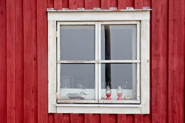 Fototapeta na wymiar Red wood building with white framed window.