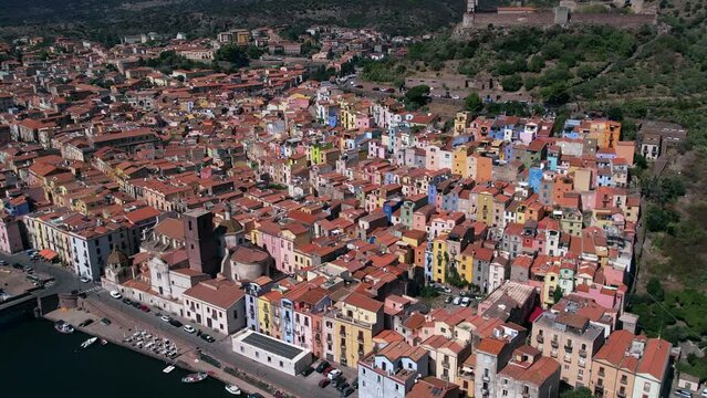 Birds eye view of ancient town and commune of Bosa city in Sardinia, Italy on banks of Temo river. Aerial.