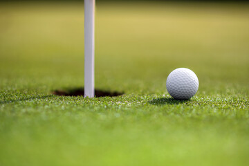 White Ball By Flagpole In Hole At Golf Course