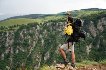 Fototapeta na wymiar Handsome happy backpacker man hiking, camping through mountain forest.