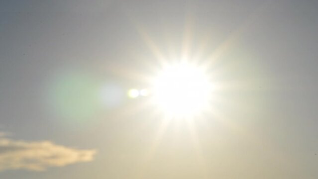 Blurred background. Sun in sky. Bright sun with sunbeams shines on clear blue sky. Bright sun light, sun ray flares, sunshine day, sunny light, sunshiny boke, lens flare. Beautiful natural background
