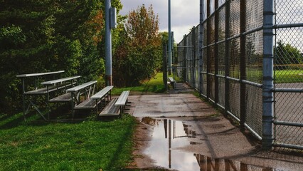 Baseball diamond and bleachers after the rain storm with trees in the background