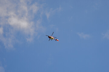 Fototapeta na wymiar helikopter hubschrauber luftrettung löschhubschrauber feuerwehr notarzt einsatz katastrophenschutz am himmel blaue wolken