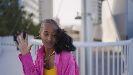 Cinematic footage of a professional hip hop female dancer outddor . Teenager girl with fashionable clothes dancing in a colored modern area of the city