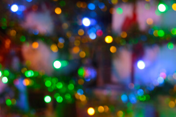 Blurry background. Bright lights of a decorated city or spruce.