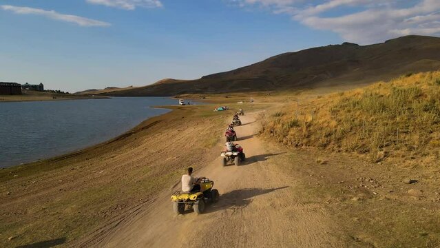 Aerial View From Behind ATVs by Lake and Mountain