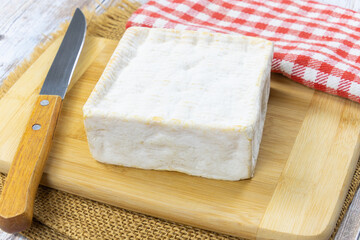 fromage Pont-l'évêque en gros plan sur une planche à découper	