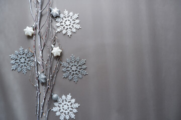 Christmas and winter holiday decoration background composition with white branches and Christmas ornaments.  Simple monotone ornamental background for banner, background and design. 