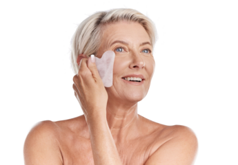 One mature woman woman using a gua sha stone for deep cell penetration against wrinkles. Happy older woman using anti ageing tool against purple copyspace background