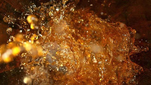 Super Slow Motion Shot of Golden Alcohol Liquid Splashing in Oak Wooden Barrel at 1000fps.