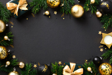 Luxury gold Christmas baubles and decorations with fir branches on black background. Xmas frame, New Year banner template. Flat lay, top view