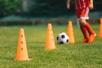 Row of Football Training Cones. Young Soccer Player Runnning Fast and Kicking Football Ball at...