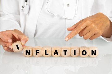 Ärztin am Schreibtisch mit dem Schlagwort INFLATION