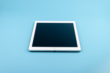 Top view of tablet on the blue pastel color background.