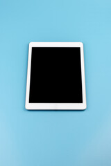 Top view of tablet on the blue pastel color background.