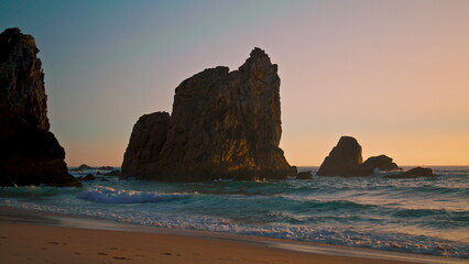 Beautiful seascape Ursa beach with rocks over Atlantic ocean surface at sunrise.