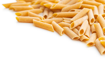 Uncooked whole grain pasta isolated on white background. Raw penne pasta.