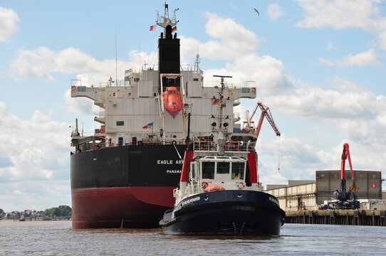 Die Eagle Arrow Panama mit Schlepper  VB Wilhelmshaven: Riesiges Containerschiff im Schlepptau beim Industriehafen Brake.