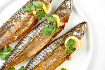 Smoked mackerel in a white plate on a white background. Close-up, selective focus.