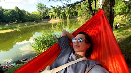 happy woman resting laying down on the hammock