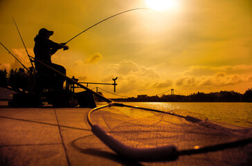 A fisherman is fishing on a spinning rod on the city embankment. 