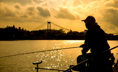 A fisherman is fishing on a spinning rod on the city embankment. 