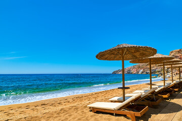 Beautiful empty beach with sun umbrellas and sunbeds ready for