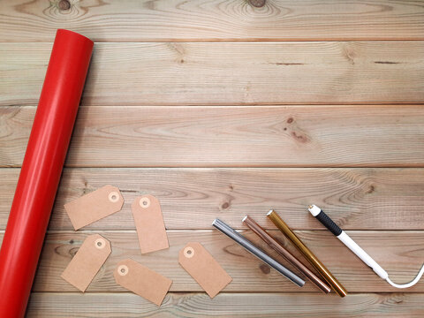 Red Paper Roll, Blank Tags And Heating Hot Stamping Pen. Flatlay. Gift Wrapping Set For Christmas And New Year. Creation Of Inscriptions With Hot Foil. DIY Packaging Concept. Copy Space For Text.