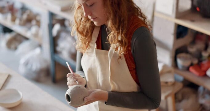 Pottery, art and design woman artist in a home studio working on creative work. Ceramic arts designer or student at a learning workshop or house preparing a clay stencil pattern on a vase project