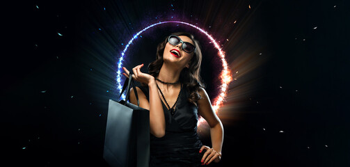 Black friday sale concept. Shopping woman holding grey bag isolated on dark background in holiday. Neon lights.