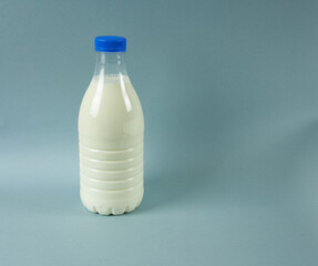 A bottle of milk close-up on a gray background.