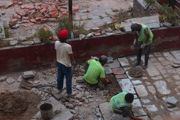 Construction workers laying some sidewalk tiles in Thimphu, Bhutan