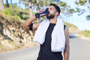Water, fitness and exercise with a sports man drinking from a bottle for hydration during his...