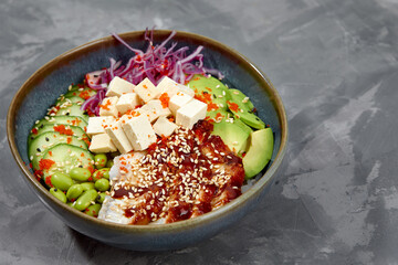 Top view on poke salad with eel and green vegetable in the bowls on gray background. Copy space.