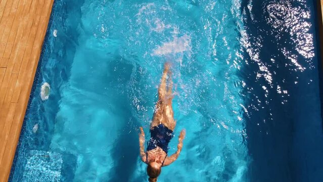 Woman swimming in a blue pool in Cyprus