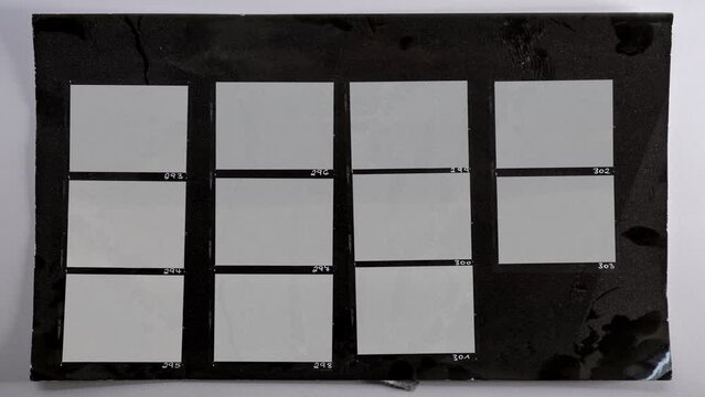 black and white hand copy contact sheet with 11 empty film frames and luma mask to blend in your work via blend mode. 4k footage.