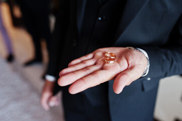 Obraz na płótnie Canvas Groom holding wedding rings in hand.