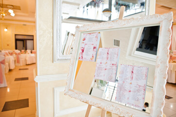 Fototapeta na wymiar Original mirror board with decoration and a guest wedding list.