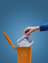 Woman putting an aluminum foil pan in the trash bin