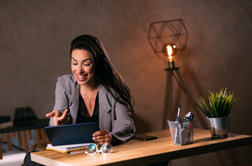 Successful businesswoman stylish using tablet computer at her office at night