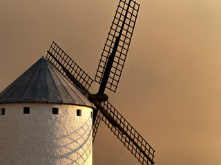 Old windmill located in the town of Campo de Criptana (Spain), on the historic route of the mills of Don Quixote, during a dramatic sunset