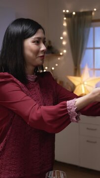 Vertical Screen: asian woman serving Christmas turkey dish in plate and letting her husband smell the aroma while they are getting ready for festive dinner at home